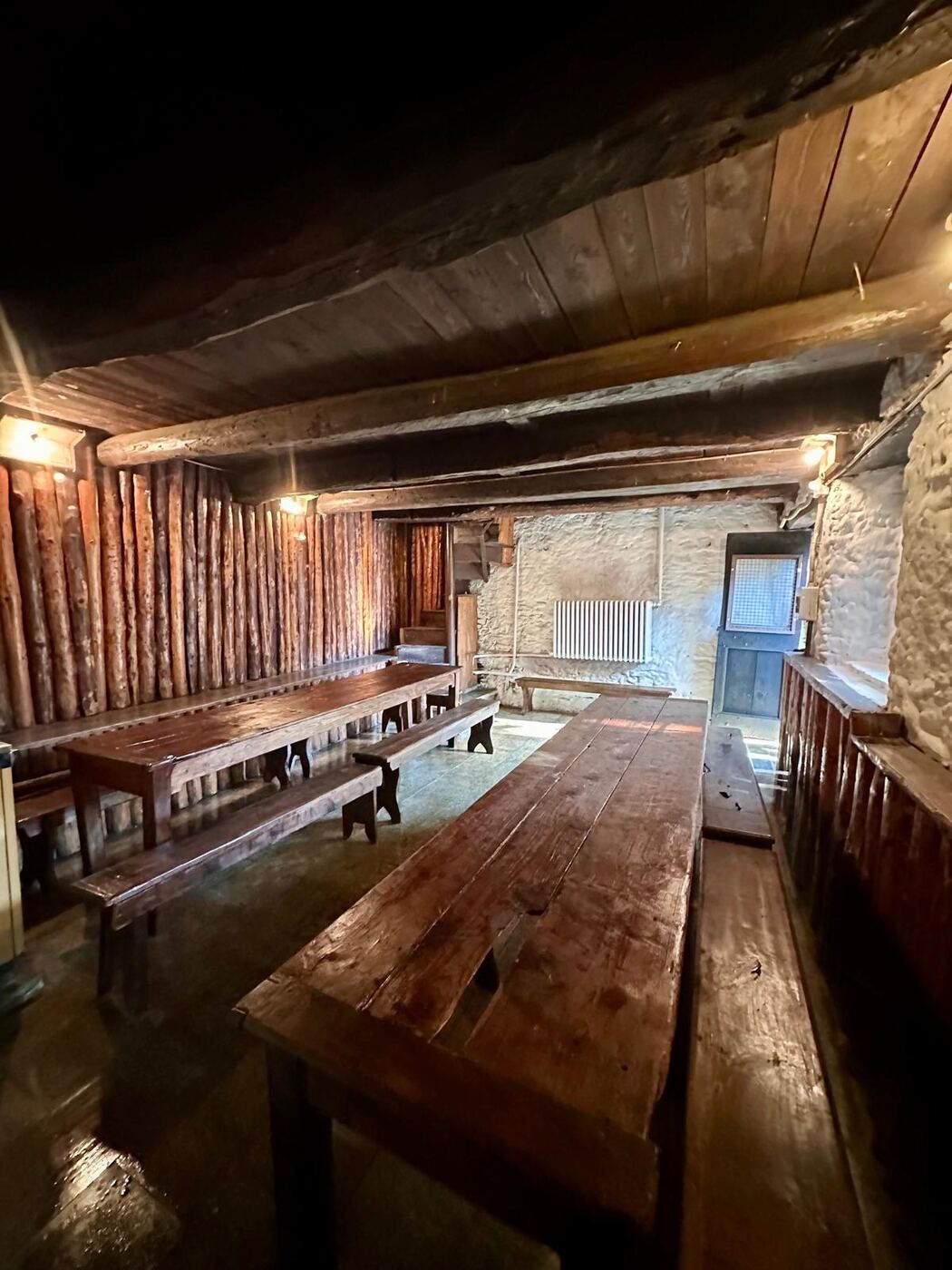 Refettorio con tavoli e panche in legno